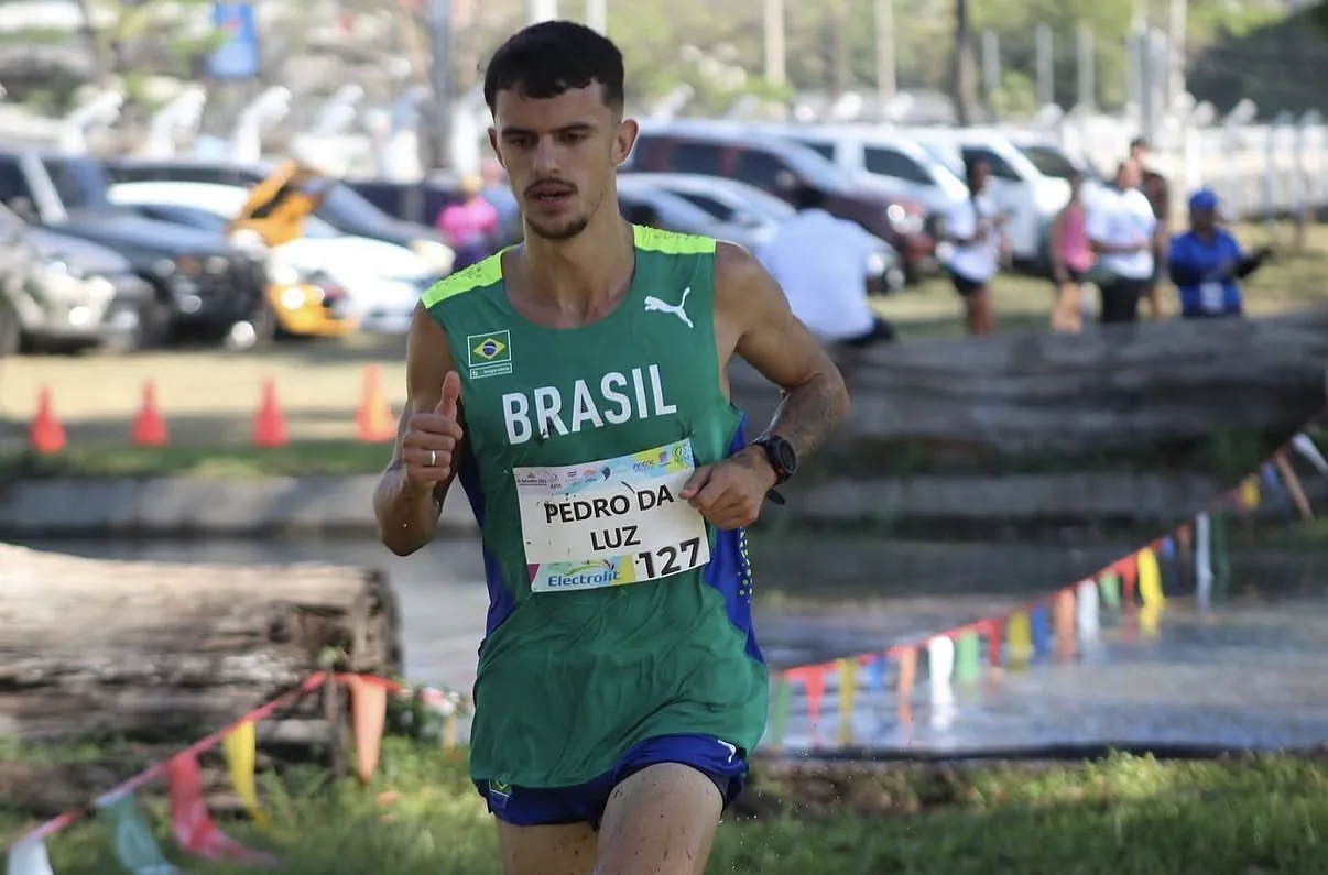 Atleta correndo com o uniforme da Seleção Brasileira em prova de cross country internacional